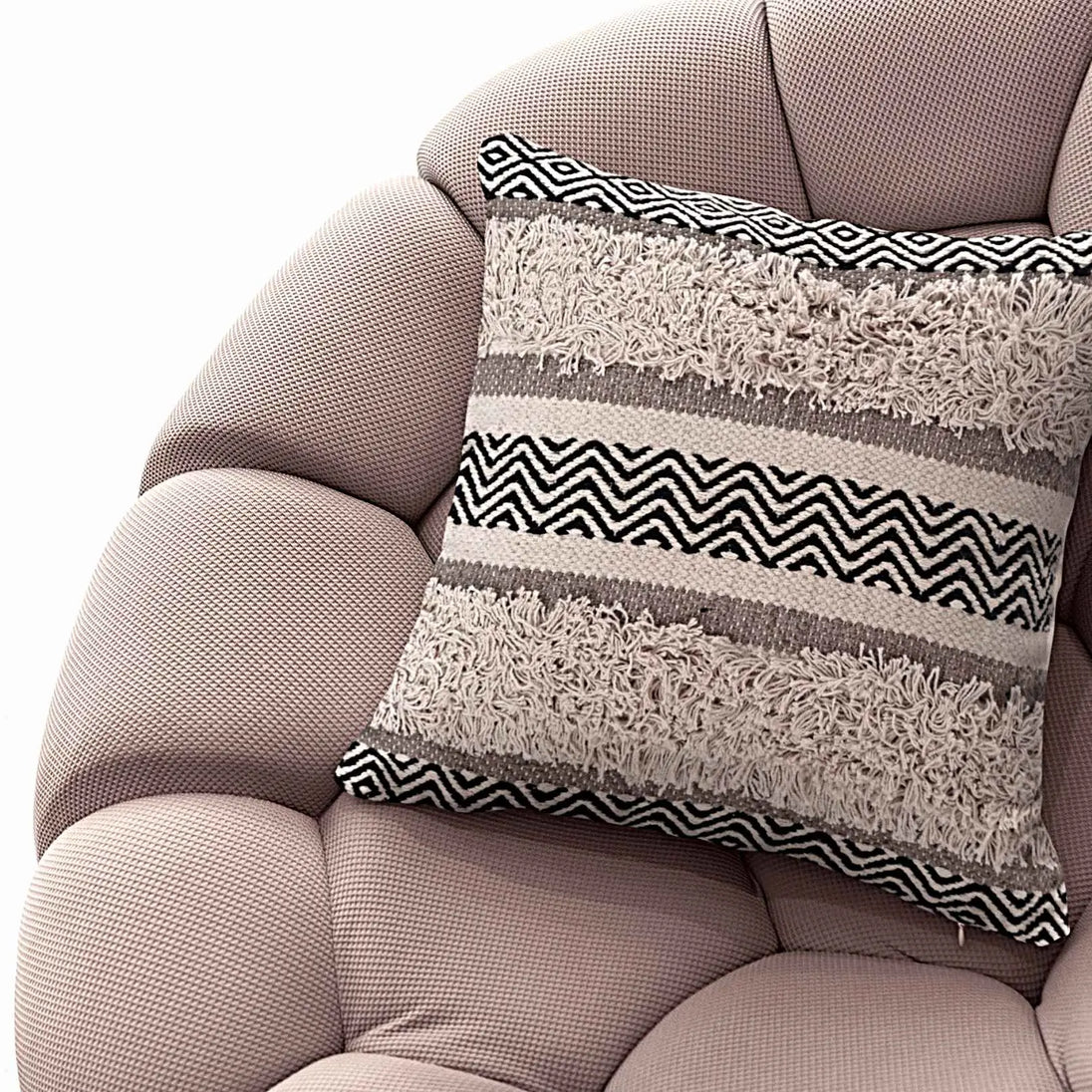 Boho accent pillow on modern textured lounge chair.