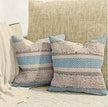 Boho throw pillow covers with blue chevron pattern, beige shaggy stripes, and gray accents, styled on a textured neutral sofa in a cozy minimalist living space.