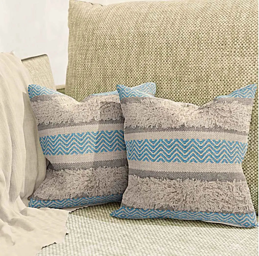 Boho throw pillow covers with blue chevron pattern, beige shaggy stripes, and gray accents, styled on a textured neutral sofa in a cozy minimalist living space.