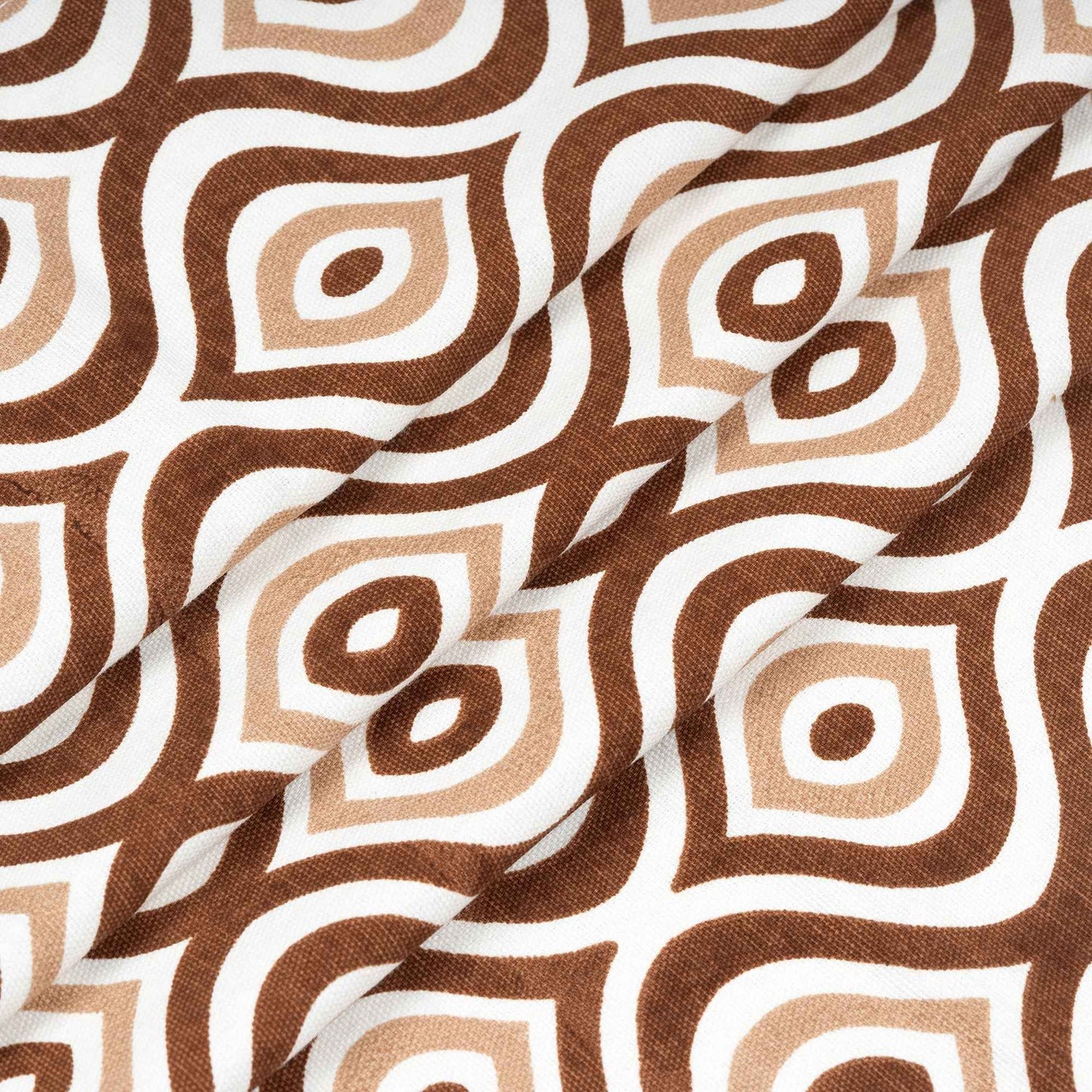 Close-up of folded brown and beige geometric patterned curtain fabric on white background, highlighting texture and print quality.