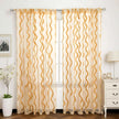 Elegant gold wave sheer curtains in bright room.
