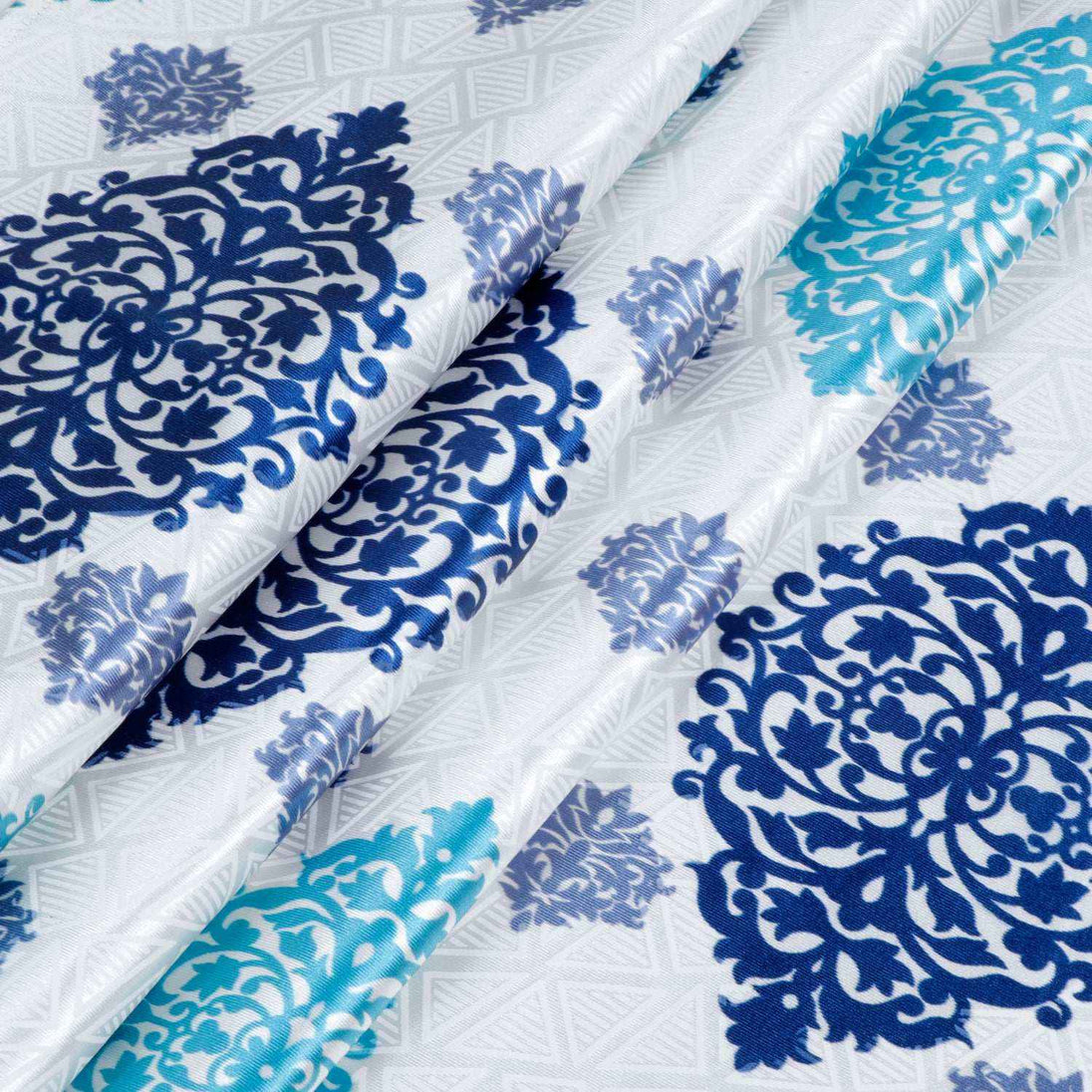 Close-up of blue and teal medallion print fabric white background
