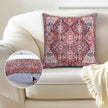 Boho-style red and gray patterned throw pillow on cream sofa with hidden zipper detail inset.
