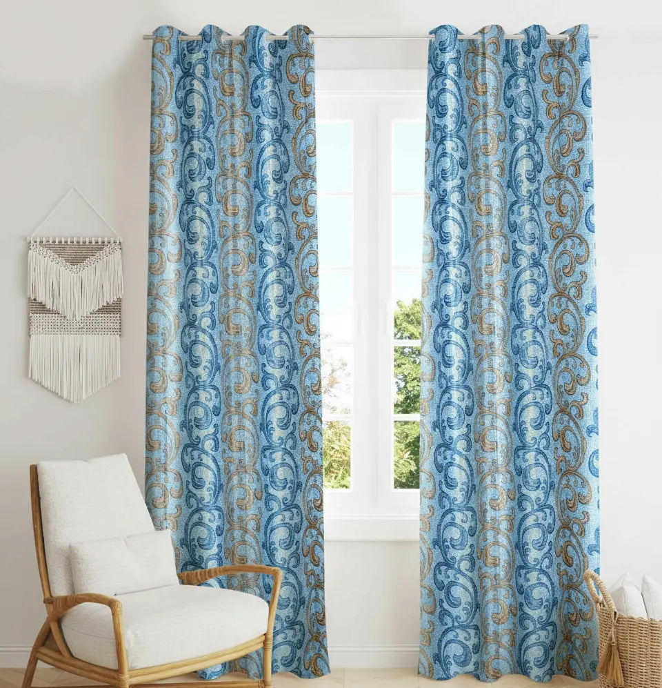 Blue patterned curtains with a white chair and decorative wall hanging in a room.