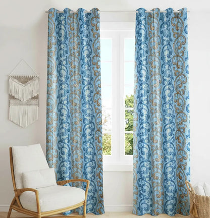 Blue patterned curtains with a white chair and decorative wall hanging in a room.
