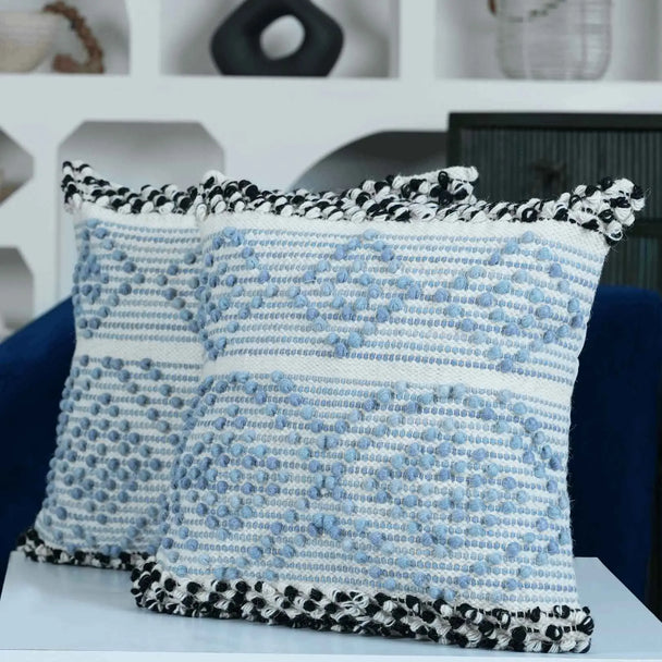 Set of two blue boho pillows with pom pom trim.
