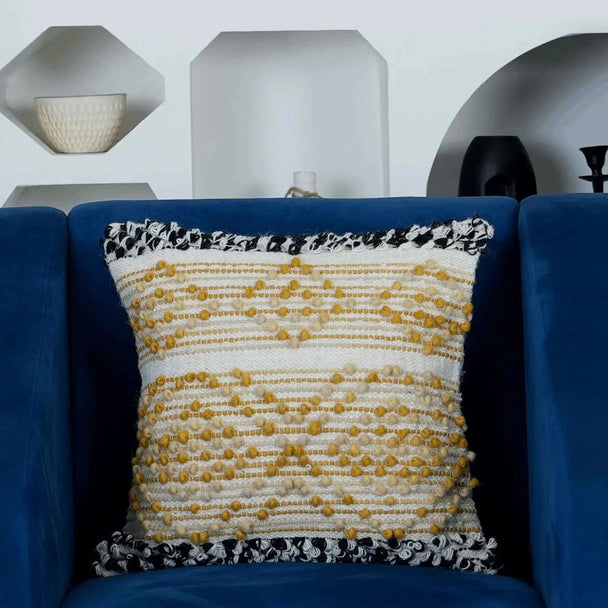 Yellow and white boho cushion on navy chair.
