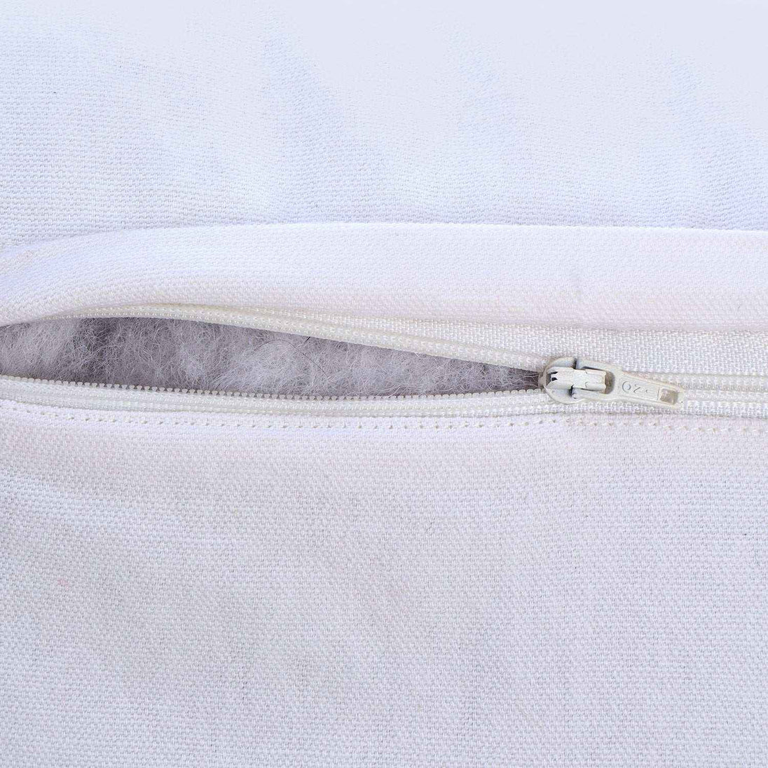 Close-up of hidden zipper on white pillow cover, showing smooth fabric texture and secure closure for easy insert placement and removal.