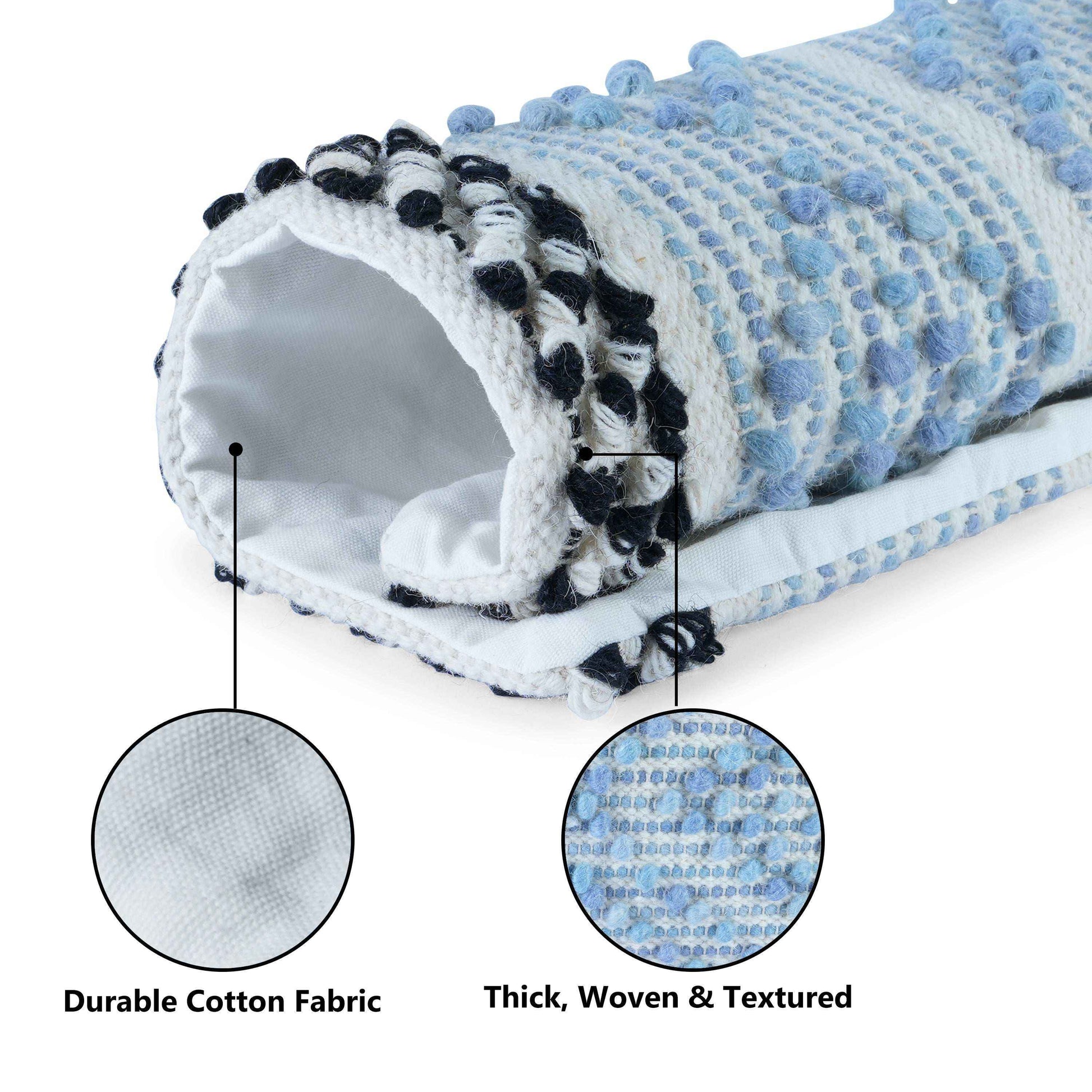 Close-up view of a rolled-up decorative cushion cover showcasing its detailed blue tufted texture and black-and-white fringed edges, with labeled callouts highlighting the durable white cotton fabric lining and the thick, woven, and textured outer material.







