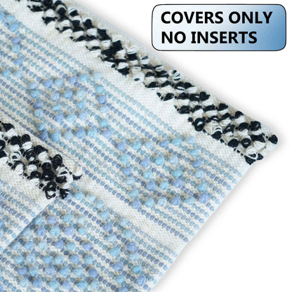 Close-up of a textured cushion cover in soft blue and white with black-and-white fringed edges, emphasizing the woven tufted pattern and a label indicating “COVERS ONLY – NO INSERTS.”







