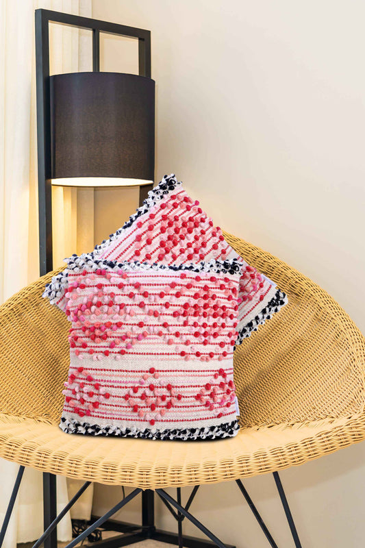 Decorative throw pillow covers featuring red and white tufted patterns with black-and-white tassel edges, beautifully styled on a woven chair—perfect for adding a textured, cozy accent to any room décor