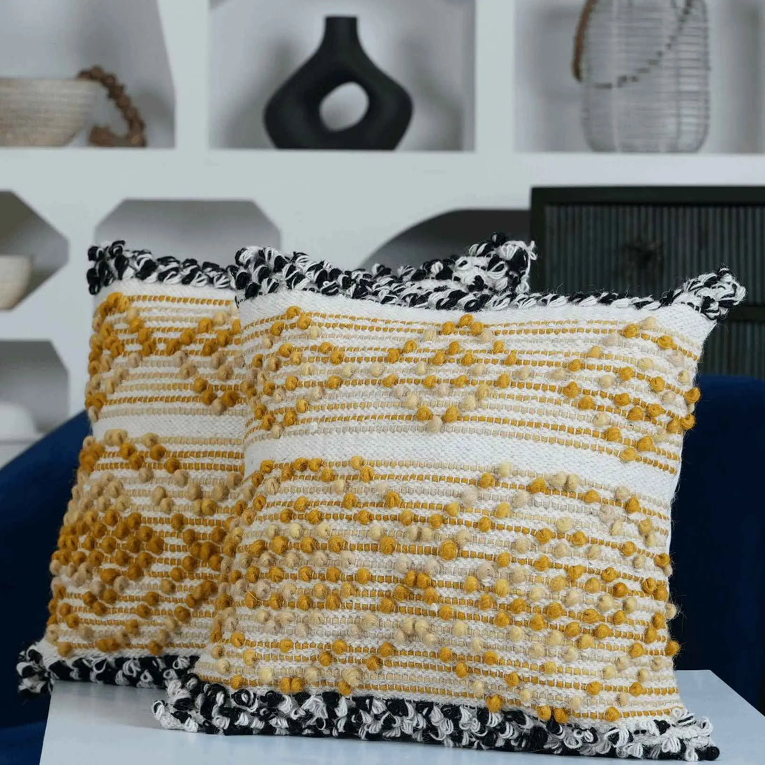 Decorative yellow and white textured cushions on sofa.
