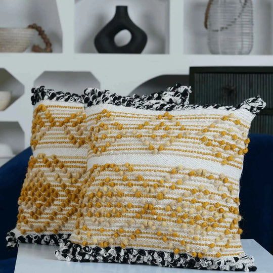 Decorative yellow and white textured cushions on sofa.
