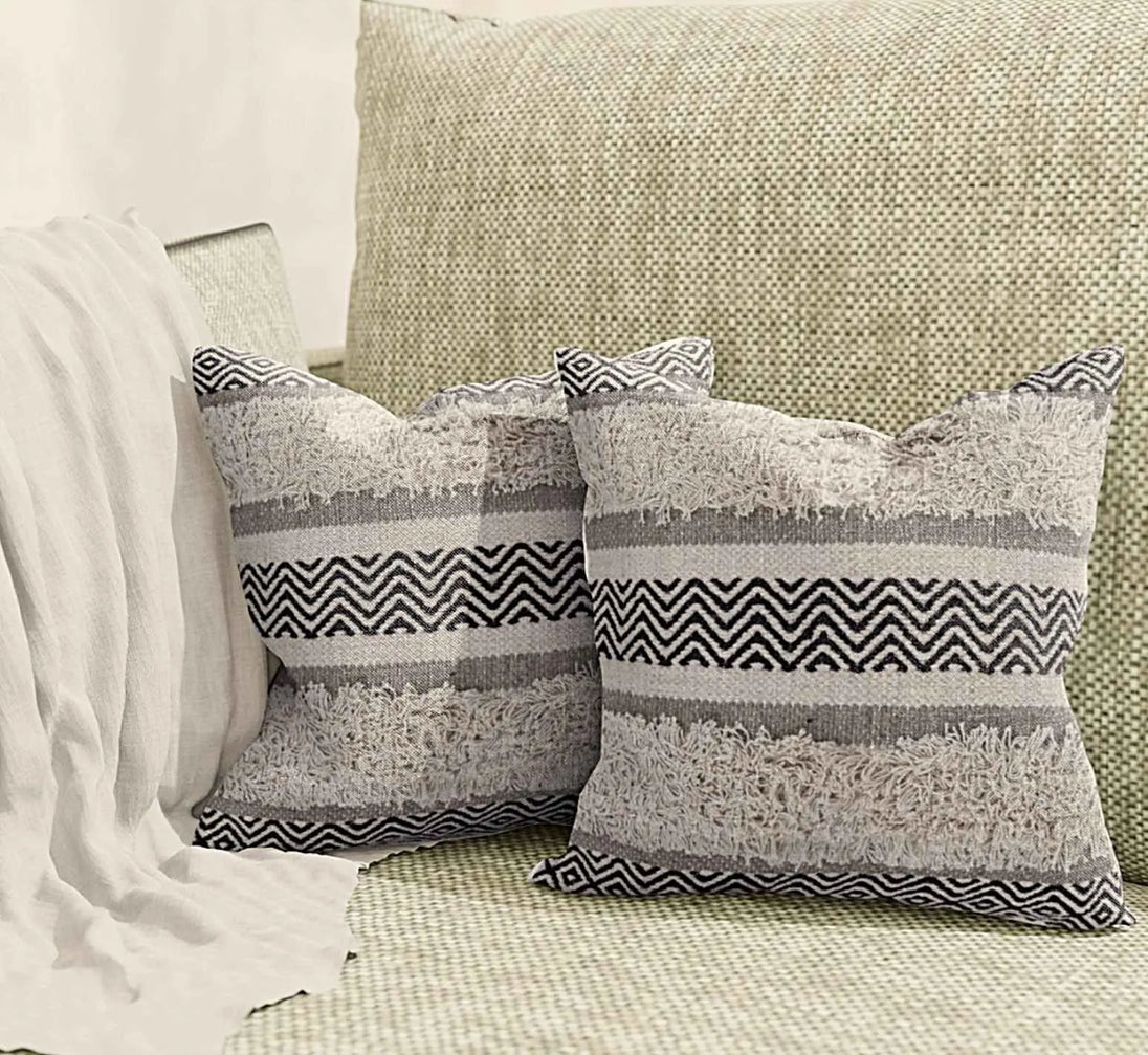 Pair of boho pillows on cozy neutral couch.
