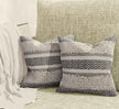 Pair of boho pillows on cozy neutral couch.
