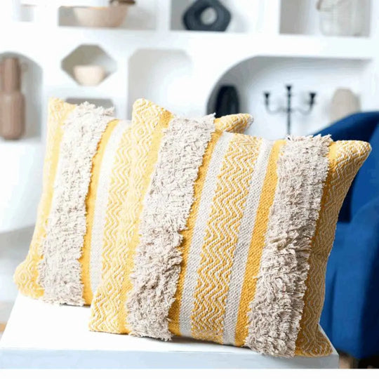Bright yellow tufted boho pillows with textured stripes.