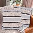 Set of two tufted decorative pillow covers with blue and ivory chevron and striped patterns, featuring thick textured cotton fabric and fluffy woven accents, displayed on a cozy beige couch in a stylish living room setting.