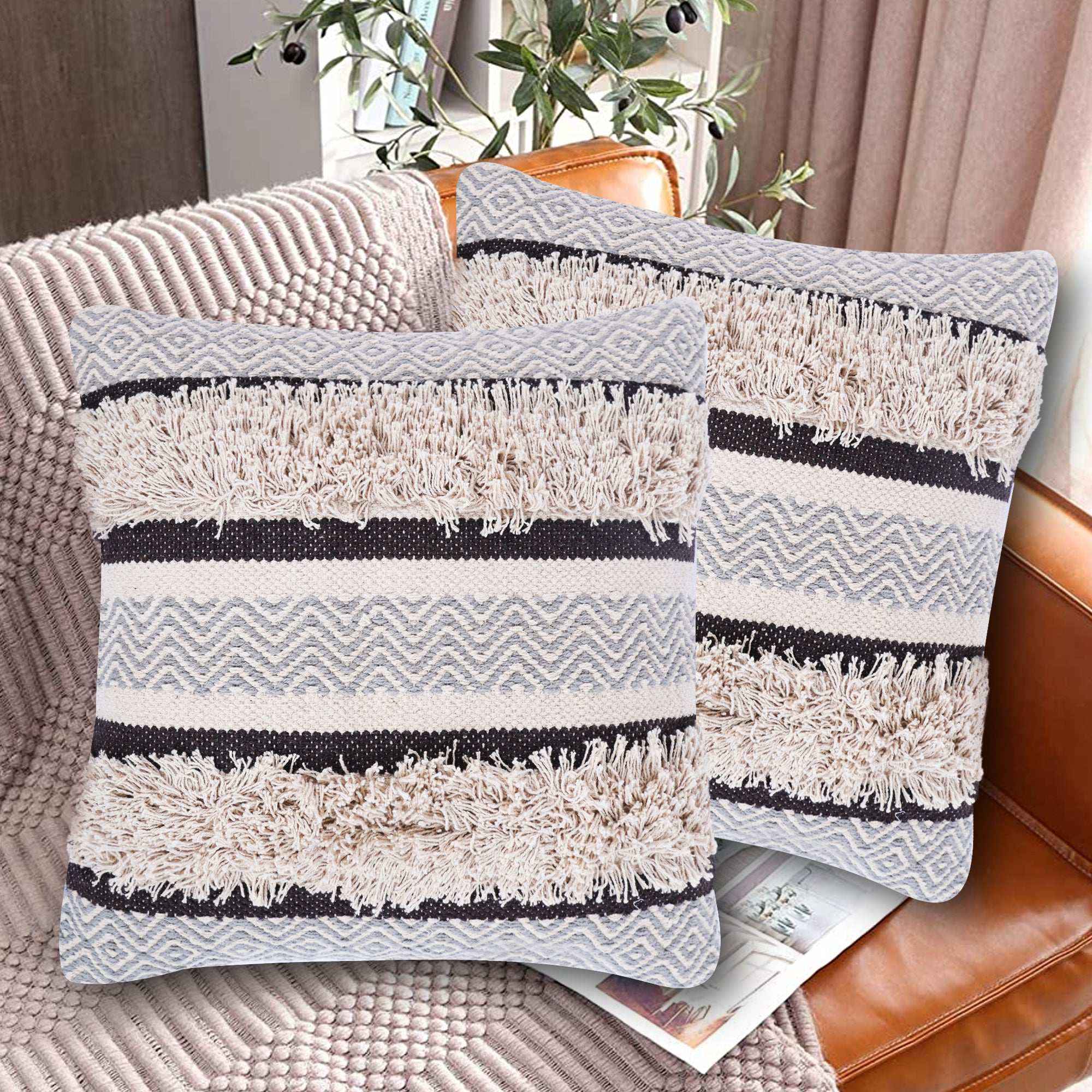 Set of two tufted decorative pillow covers with blue and ivory chevron and striped patterns, featuring thick textured cotton fabric and fluffy woven accents, displayed on a cozy beige couch in a stylish living room setting.