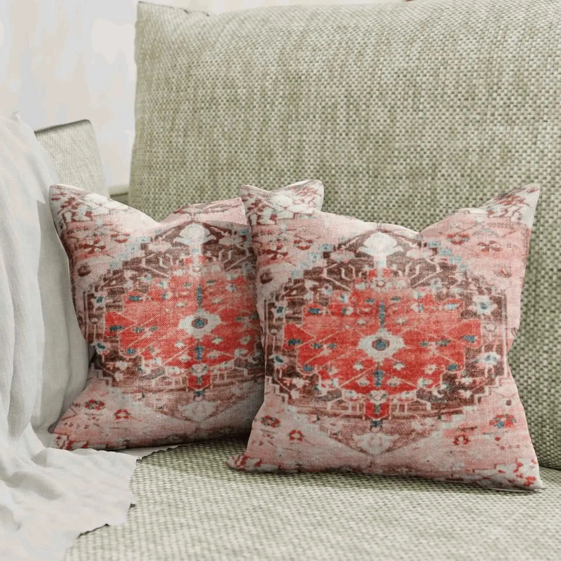 Vintage red medallion throw pillows on green sofa.
