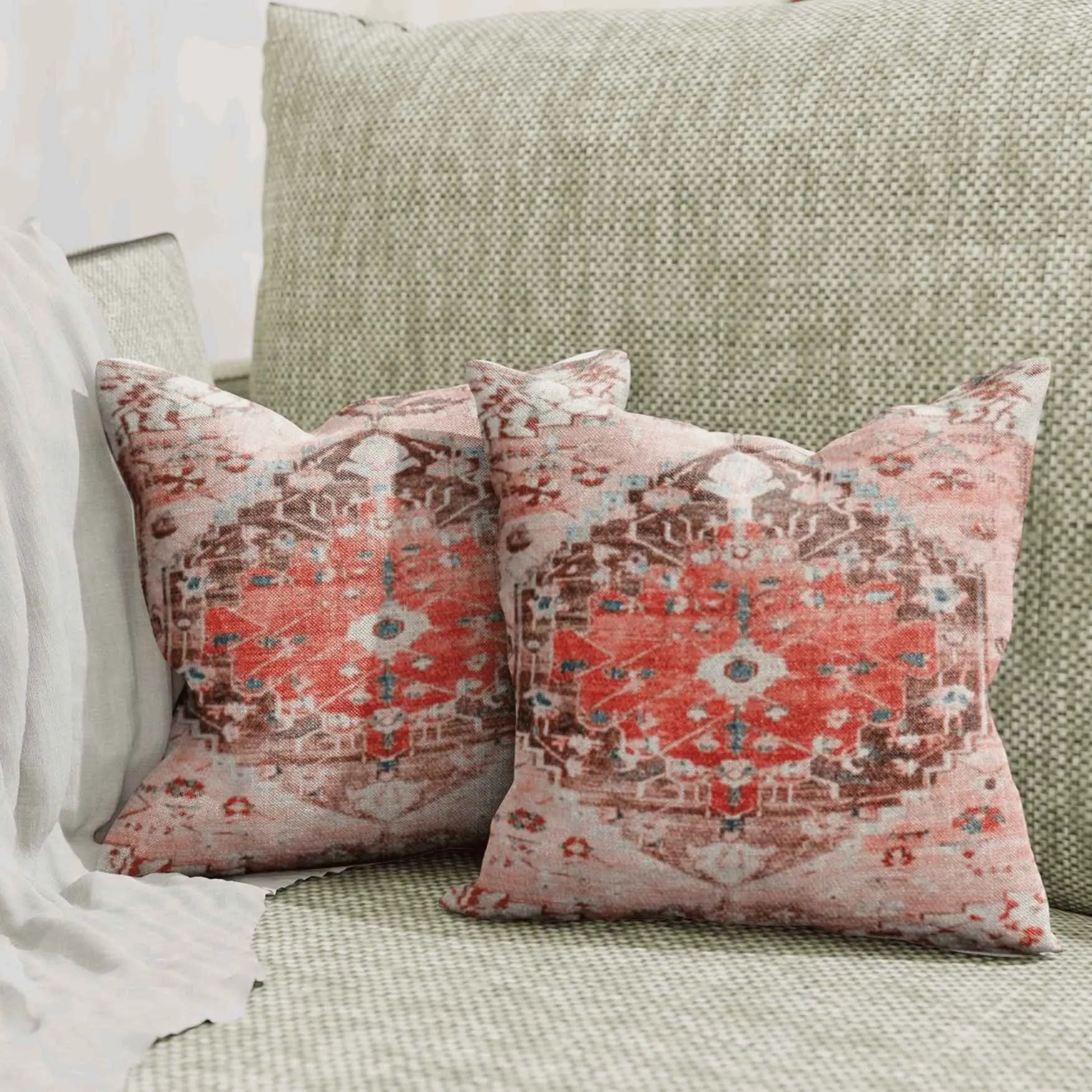 Vintage red medallion throw pillows on green sofa.
