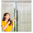 Smiling woman pointing at elegant sheer curtains.
