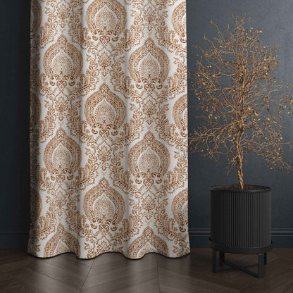 Elegant brown and white damask curtain with intricate pattern, styled in a modern room next to a decorative dried tree in a black planter on dark wood flooring.