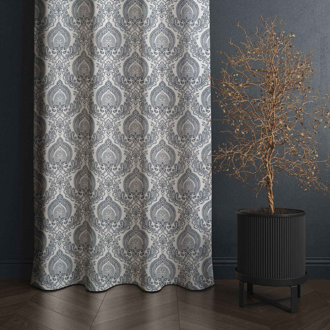 Gray damask curtain beside decorative potted tree.
