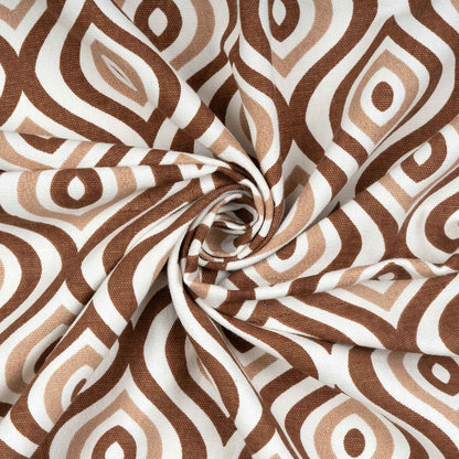 Close-up of twisted fabric with brown and beige geometric pattern on white background, showcasing texture and print detail.