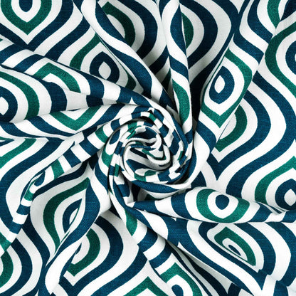 Close-up of twisted fabric with green and navy blue geometric diamond pattern on white background, highlighting texture and print detail.