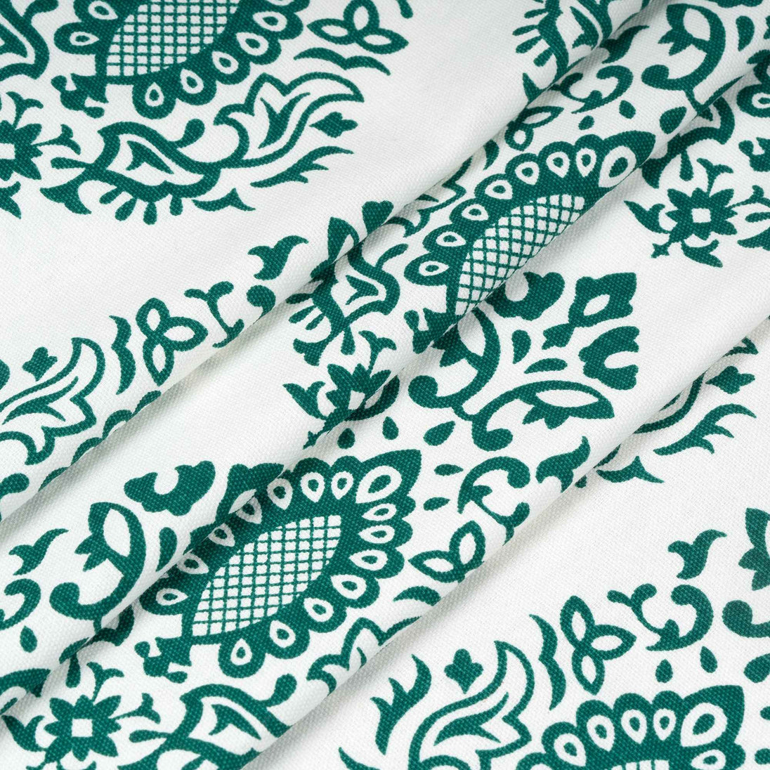 Close-up of folded fabric with green floral print.
