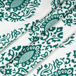 Close-up of folded fabric with green floral print.
