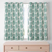 Green damask curtains hanging on window above dresser.
