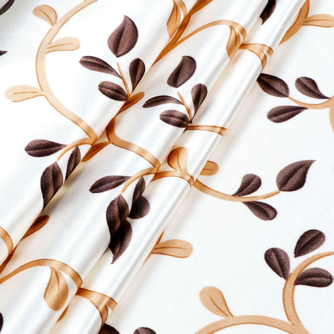 Close-up of white curtain fabric with a gold and brown leafy vine print, 