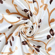 Close-up of white curtain fabric with gold vine and brown leaf pattern, 